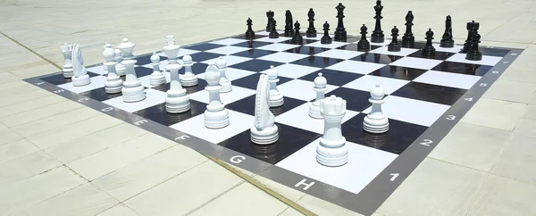 Textura, fondo. Antecedentes Gran ajedrez en el parque. Gran juego de ajedrez en el suelo en el parque. Grandes piezas de ajedrez jugando al juego en el piso. Ajedrez gigante en el tablero ubicado en el suelo  . — Foto de Stock