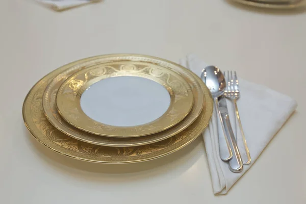 Красиво оформленный стол с белыми тарелками, льняной салфеткой, ложкой, вилкой  . — стоковое фото