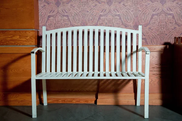 Clean empty room with wooden floors and textured wall and bench in white . White iron bench wooden background . — 스톡 사진