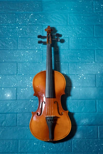 Cartel de concierto de música clásica con violín de color naranja sobre fondo azul con espacio para copiar el texto. Violín y alquitrán azul en el fondo.Violín delante de la pared de ladrillo azul  . —  Fotos de Stock