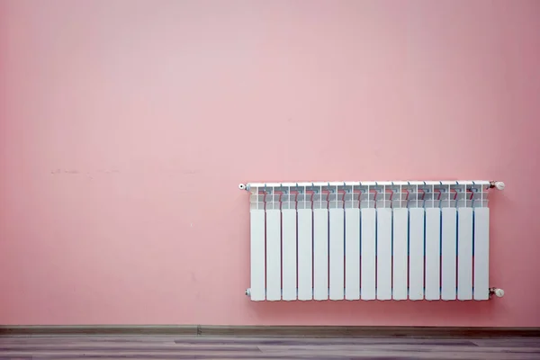 Maison chauffage au gaz gros plan .Chauffage radiateur sur un mur rose à un appartement. Salon moderne. Radiateur dans la chambre. Système de chauffage. Un rendu 3D. Radiateur chauffant dans une pièce blanche avec parquet stratifié — Photo