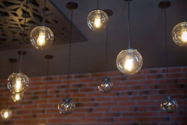 Parlak, geçmişe dönük, lüks lamba dekoru. Geceleri duvarda asılı duran klasik farklı retro ampuller. Dekoratif antika edison tarzı ampuller tuğla duvara karşı.