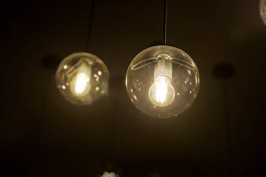 Parlak, geçmişe dönük, lüks lamba dekoru. Geceleri duvarda asılı duran klasik farklı retro ampuller. Dekoratif antika edison tarzı ampuller tuğla duvara karşı.