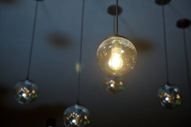 Parlak, geçmişe dönük, lüks lamba dekoru. Geceleri duvarda asılı duran klasik farklı retro ampuller. Dekoratif antika edison tarzı ampuller tuğla duvara karşı.