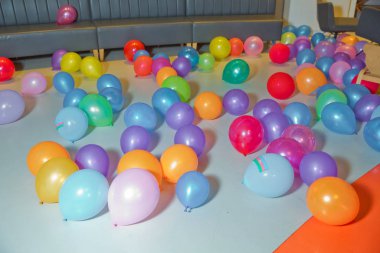 Yerde farklı renkte balonlar var. Renkli balon yatağı. Tatil, çocuk partisi, oyun odası, küçük renkli toplarla dolu bir kutu.