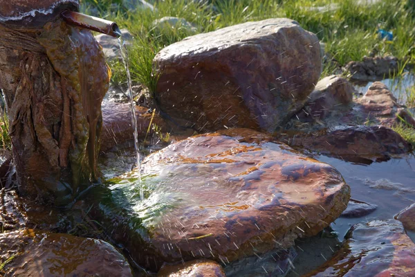 Air Mengalir Dari Pipa Dengan Latar Belakang Pegunungan Yang Kabur — Stok Foto