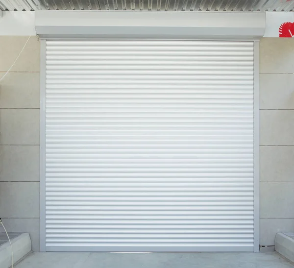 Automatic Electric Roll-up Gate Or Push-up Door In The Modern Building Ground Floor . Shutter door or roller door and concrete floor outside .White Automatic shutters in a house . gates in the garage