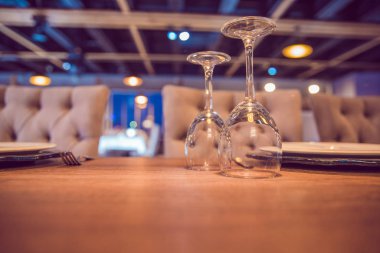 Ahşap masaya boş ters çevrilmiş cam. Açık hava restoran masası, masada ters çevrilmiş boş bardaklar. Kafedeki masada sofra takımı, fırın sapına odaklan .