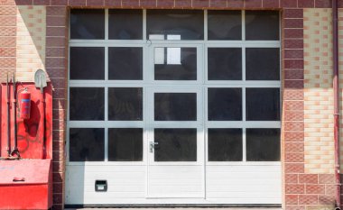 Alüminyum kompozit ve beyaz kapı girişi. Ofis kapısı ve penceresinde fotokopi odası var. Cam kapı ofisi ve el.