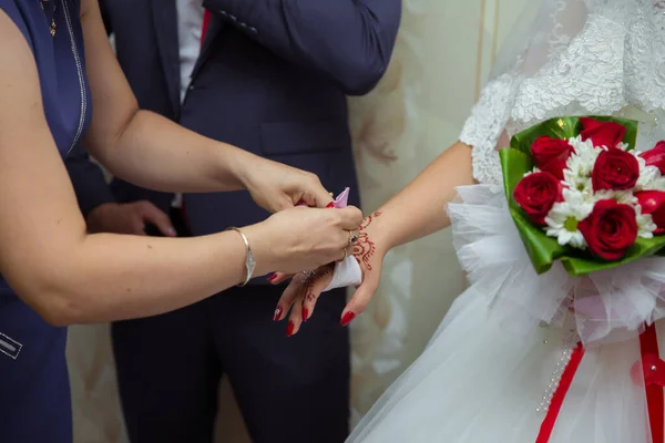 伴娘帮助把一个手镯放在他的手臂上给新娘 新娘戴上首饰 专注于手镯 新郎在婚礼当天送给新娘手镯作为他爱的象征 — 图库照片