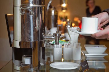 Bir elde kahve espresso. Kahve makinesinden taze kahve dökülen bir el. Profesyonel espresso makinesi, taze kahveyi düzgün bir fincana dolduruyor. .