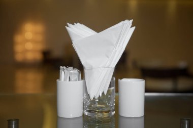 Kafede ya da restoranda bir masa. Metal peçetede beyaz peçeteler, ahşap bir masada tuz ve biber baharatları, panoramik manzara. kürdan