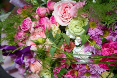 Taze kırmızı, beyaz, pembe güller. Bir buket çok renkli gül. Kırmızı çiçek resmi buketin içinde. Çiçeğin yaprağı.