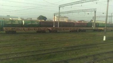 Yolcu treninin penceresinden yaklaşan bir yolcu gemisi. Tren yolu penceresi. Otoyol manzarası. Hareket halindeki trenin penceresinden bak. Manzarada demiryolu var. Geçerken pencereden dışarı bakıyorum. .