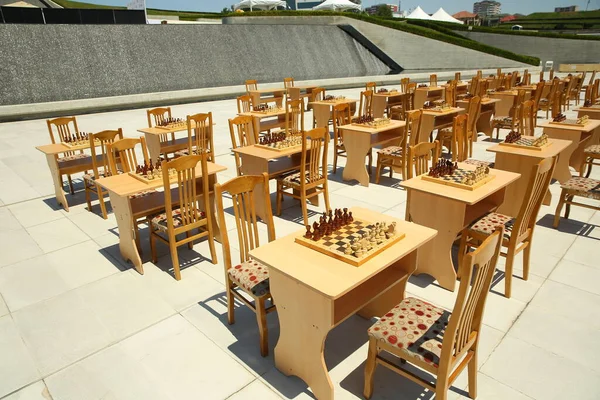 Chess board with yellow and brown figures . Yellow and brown photo with a picture of a chess Board pieces, Wooden pieces on a chess Board and emtye table . How to play wooden chess game.