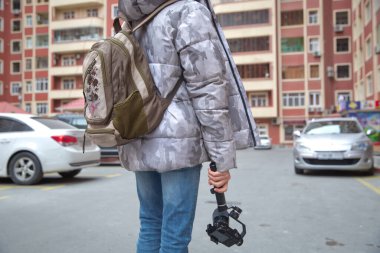 Bir adam kamerayı vibratöre monte etmiş. Siyah ekipmanlı Gimbal Operatörü - Stabilizer ve kamera yapımı