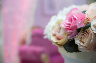 Düğün günü masada güzel pembe ve beyaz çiçekler. Düğün masası, düğün süslemeleri. Güzel güllerle dolu büyük vazo yemek masasının üzerinde duruyor. Misafirler için düğün çiçeği kompozisyonu.