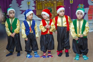 Bakü, Azerbaycan. 26.01.2020. Çocuklar kırmızı Noel Baba gibi giyinmiş. Anaokulu katılımcıları bir Yeni Yıl etkinliğine katılıyor. Kırmızı Noel Baba kostümleri giymiş şirin çocuklar.