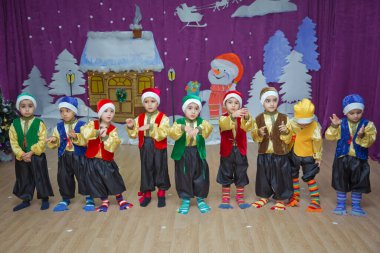 Bakü, Azerbaycan. 26.01.2020. Çocuklar kırmızı Noel Baba gibi giyinmiş. Anaokulu katılımcıları bir Yeni Yıl etkinliğine katılıyor. Kırmızı Noel Baba kostümleri giymiş şirin çocuklar.