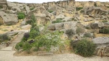 Gobustan milli parkındaki manzara, uzaklarda pavyon, insanlar ve Gobustan yerleşimi.