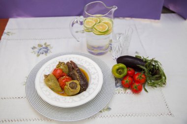 Tabağa patlıcan doldurdum. Patlıcanlar et ve pirinçle doldurulur. Patlican. Patlıcan dolgusu. Patlıcan, biber, domates. Kahverengi kasede yoğurt. Cam kavanozda doğranmış limon. .