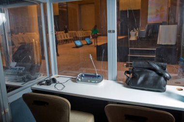 Çevirmenler odacık. yorumlama - mikrofon ve geçiş panosunda bir simultane tercüman booth. Yumuşak odak kablosuz konferans mikrofonlar ve not defterinde bir toplantı salonu.