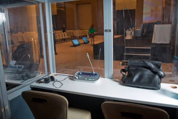 Çevirmenler odacık. yorumlama - mikrofon ve geçiş panosunda bir simultane tercüman booth. Yumuşak odak kablosuz konferans mikrofonlar ve not defterinde bir toplantı salonu.