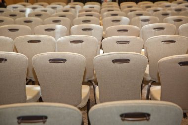 Konferans salonunda, iş toplantısından hemen önce. Toplantı odasında beyaz sandalyeler. Toplantı salonunda boş koltuk.