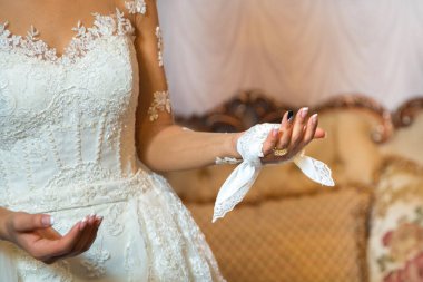 Gelin, mendili onun ellerine verir. Damat gelinin eline bir mendil bağladı..