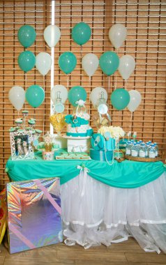 Bakü, Azerbaycan. 20.04.2017. Mavi plaj temalı oyuncak bebek pastası. Kızlar için doğum günü pastası. Pasta şefi dekore ediyor. Kız bebekler gibi ev yapımı zencefilli çörekler. Kız bebek ve su keki. Şeker çubuğu