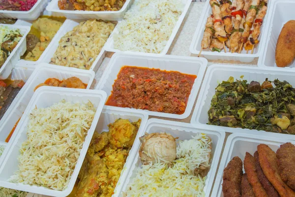 Plastik kutularda çeşitli fast food çeşitleri. Kutularda sağlıklı ve lezzetli yiyecekler var. Shah pilav. Et pirzolası. Patlıcan dolması. Doldurulmuş et