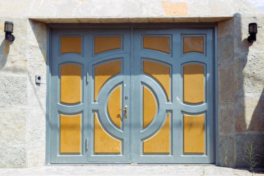 Otomatik elektrikli çekiş kapısı ya da modern binanın zemin katındaki şınav kapısı. Kepenk ya da paten kapısı ve beton zemin dışarıda. Sarı, gri otomatik panjurlar bir evde. Garajdaki kapılar