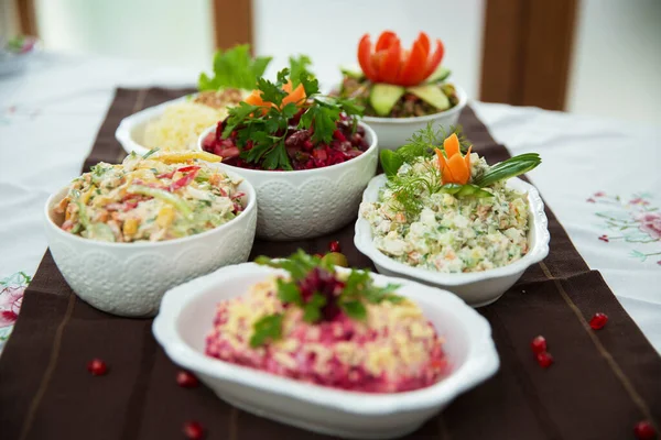 Büyük boy ve Mimosa salatası. Lahana salatası. Farklı salatalarla hazırlanmış. Salata jambonu, portakal biberi, mantar, turşu, beyaz kase üzerinde beyaz sos. Pancarlı diyet salatası. Kahverengi masa örtüsü