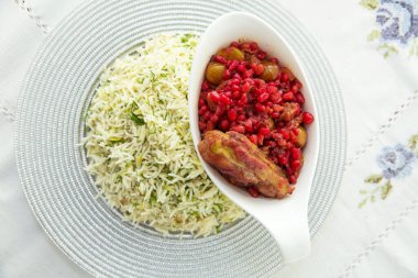 Beyaz bir tabakta pilav içinde doğranmış dereotu. Beyaz masa örtüsü üzerinde Şah pilav. Fırında nar tohumu ve tavuk. Canlı Nar beyaz bir masa örtüsünün üzerinde. Kavrulmuş nar tohumları. .