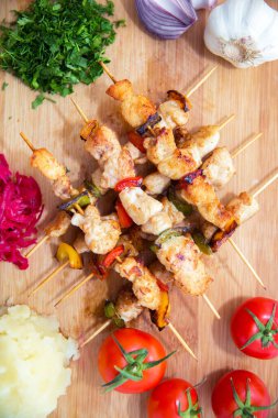 Ahşap bir şişte kuzu kebabı. Şiş kebap seti. Tahta üzerinde biftek kebabı. Kırmızı lahana turşusu. Patates püresi. Sarımsak, soğan, domates. Doğranmış kişniş. .