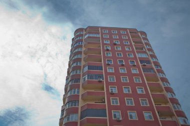 BAku yakınlarındaki modern çok katlı turuncu bina cephesi. Yeni apartman. Çok katlı evler modern. Mavi gökyüzünün altındaki yüksek binalar