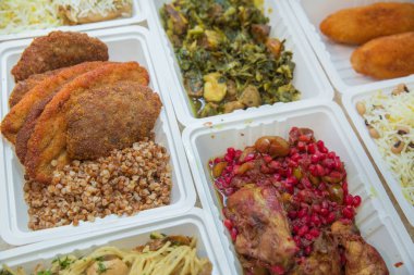Plastik kutularda çeşitli fast food çeşitleri. Kutularda sağlıklı ve lezzetli yiyecekler var. Kızarmış et ve sebze. Et pirzolası, fırında karabuğday. .