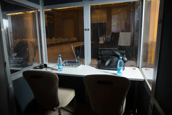 Çevirmenler odacık. yorumlama - mikrofon ve geçiş panosunda bir simultane tercüman booth. Yumuşak odak kablosuz konferans mikrofonlar ve not defterinde bir toplantı salonu.