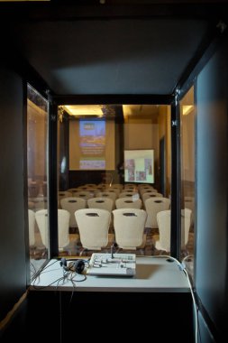Çevirmenler odacık. yorumlama - mikrofon ve geçiş panosunda bir simultane tercüman booth. Yumuşak odak kablosuz konferans mikrofonlar ve not defterinde bir toplantı salonu.
