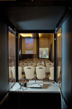 Çevirmenler odacık. yorumlama - mikrofon ve geçiş panosunda bir simultane tercüman booth. Yumuşak odak kablosuz konferans mikrofonlar ve not defterinde bir toplantı salonu.