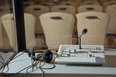 Çevirmenler odacık. yorumlama - mikrofon ve geçiş panosunda bir simultane tercüman booth. Yumuşak odak kablosuz konferans mikrofonlar ve not defterinde bir toplantı salonu.