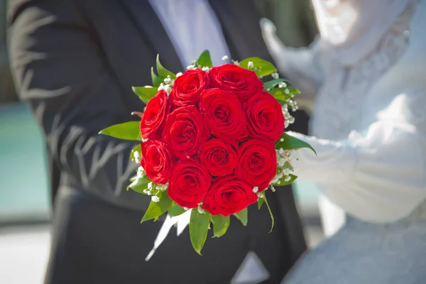 Menyasszony Vőlegény Egy Csokor Vörös Virágot Tart Homályos Háttér — Stock Fotó