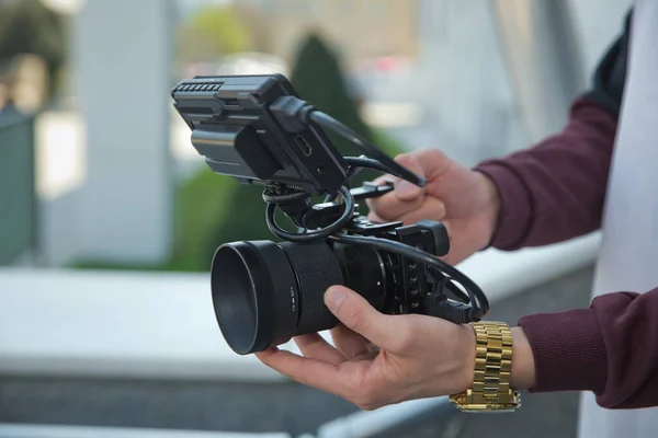 Man holding gimbal stabilizer outdoor. Gimbal Operator with black equipament - Stabilizer and camera filmmaking . An unidentified man holding gimbal a camera stabilizer .