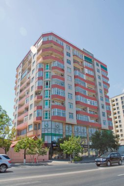 BAku yakınlarındaki modern çok katlı turuncu bina cephesi. Yeni apartman. Storey modern bir ev. Mavi gökyüzünün altındaki yüksek binalar