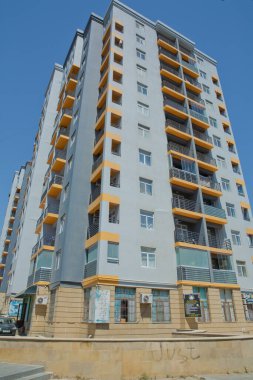 BAku yakınlarındaki modern çok katlı turuncu bina cephesi. Yeni apartman. Storey modern bir ev. Mavi gökyüzünün altındaki yüksek binalar