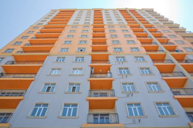 BAku yakınlarındaki modern çok katlı turuncu bina cephesi. Yeni apartman. Storey modern bir ev. Mavi gökyüzünün altındaki yüksek binalar