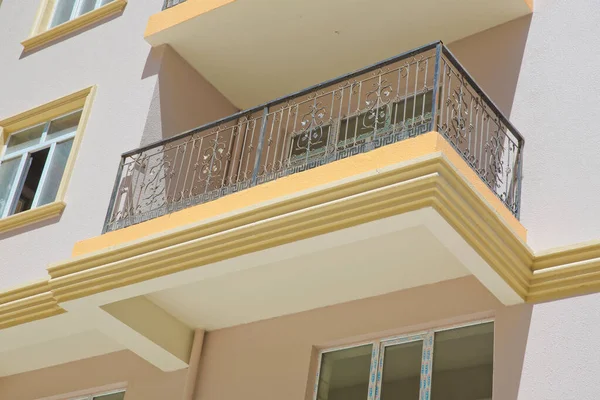 Zarif dekoratif taş balkon. Klasik beyaz binanın düşük seviye perspektifi. Balkonlar ve duvarlar beyaz. Taş bir binanın pencere balkonunda. .