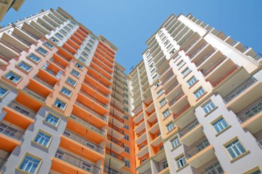 Azerbaycan Bakü 04.08, 2017. Bakü yakınlarındaki modern çok katlı turuncu bina cephesi. Yeni apartman. Storey modern bir ev. Mavi gökyüzünün altındaki yüksek binalar