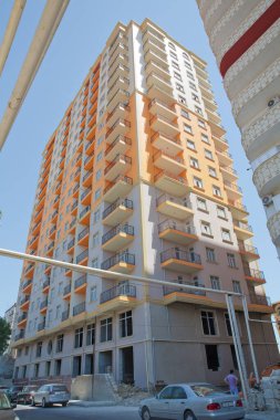 Azerbaycan Bakü 04.08, 2017. Bakü yakınlarındaki modern çok katlı turuncu bina cephesi. Yeni apartman. Storey modern bir ev. Mavi gökyüzünün altındaki yüksek binalar