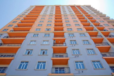 Azerbaycan Bakü 04.08, 2017. Bakü yakınlarındaki modern çok katlı turuncu bina cephesi. Yeni apartman. Storey modern bir ev. Mavi gökyüzünün altındaki yüksek binalar